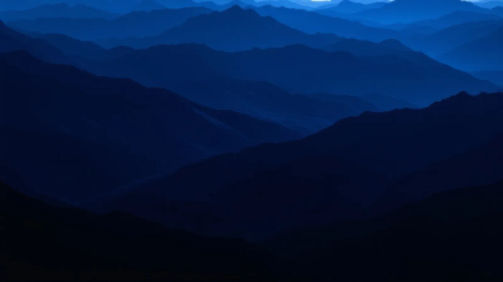 Deep blue mountain ridges at blue hour with a thin line of pale light on the horizon, the IndigAlta view of installment loans online, $100 – $5,000